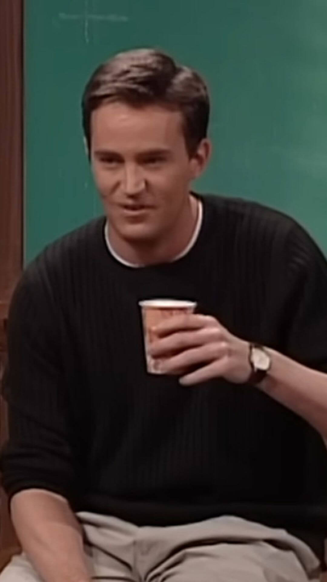 mathhew perry from popular show friends teaching the class on Sarcasm holding a cup