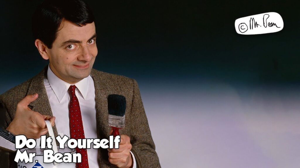 mr bean standing in a dark room with a mike in hand