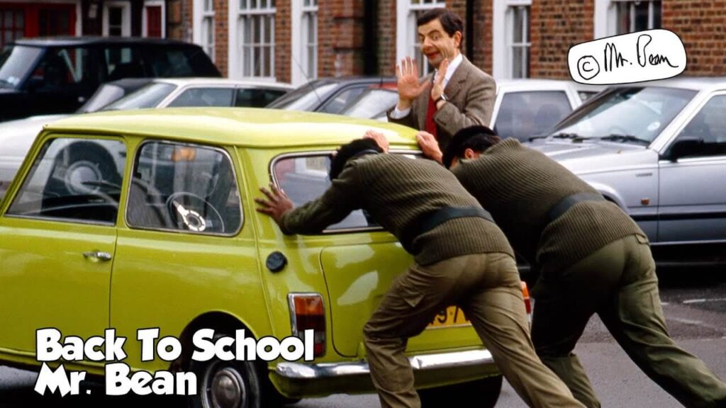 mr bean getting two men to push his green car and smiling in joy