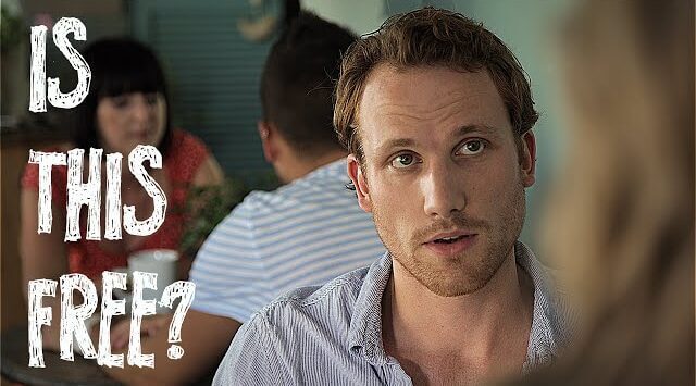 a man in a blue shirt sitting on a chair in a restaurant